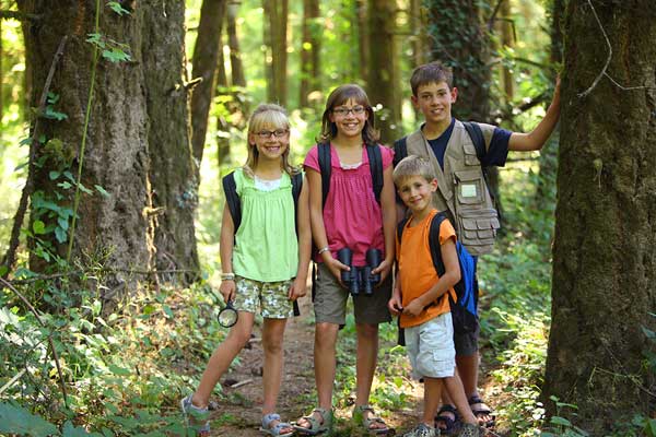 Kids-hiking-summer 在炎热的夏天,不同年龄的孩子们在公园里徒步旅行。