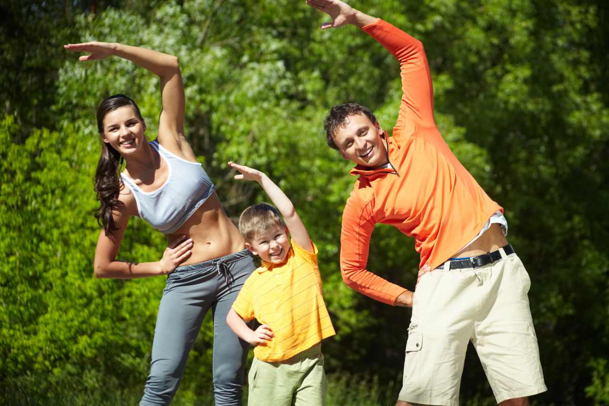 Portrait of family of three doing physical exercise in park