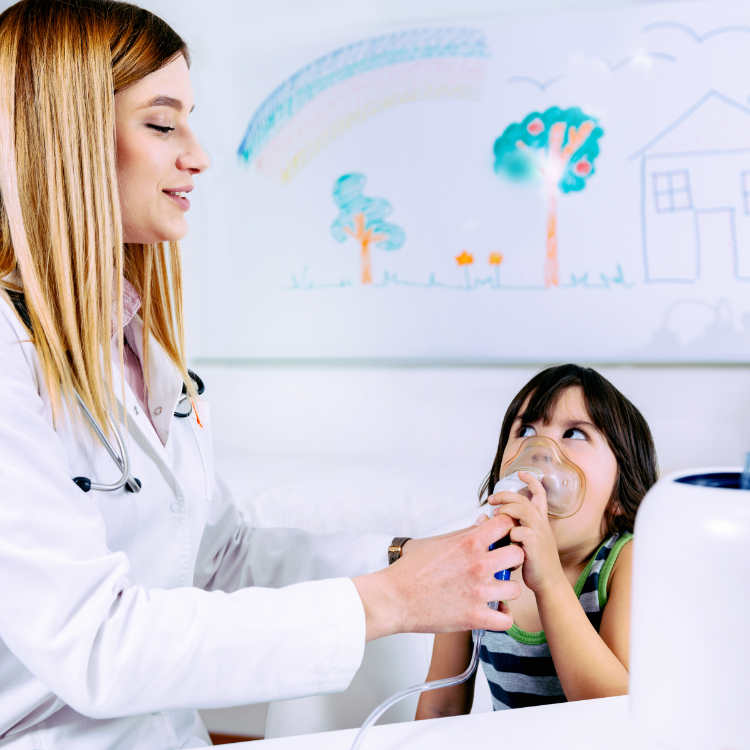 School nurse using respiratonic inhaler for little boy